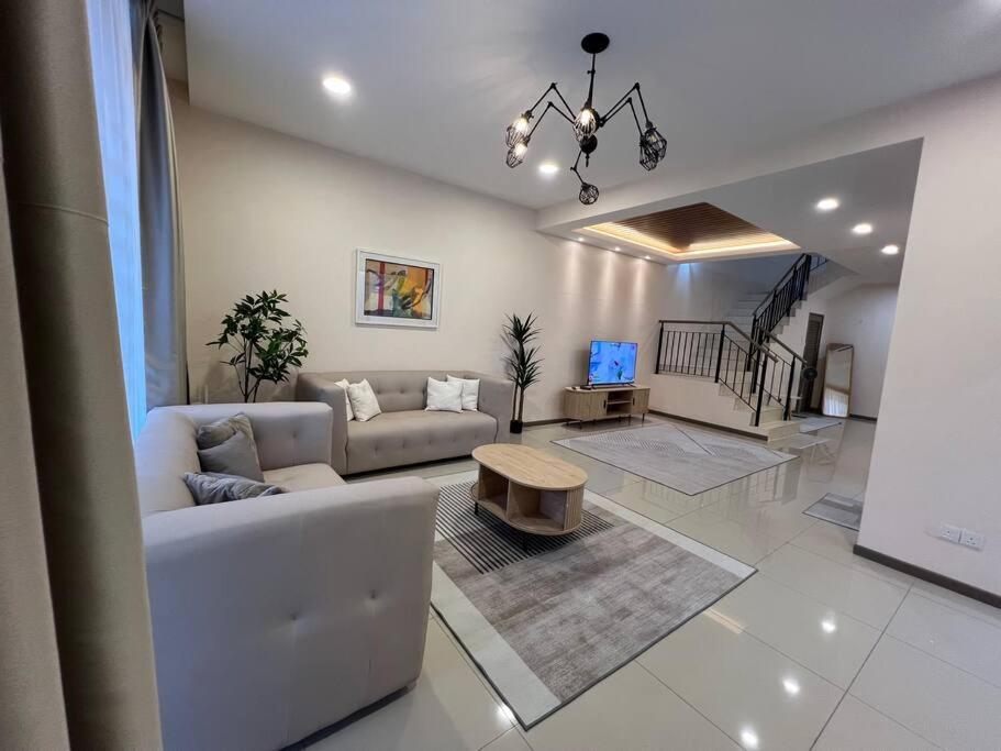 a living room with a couch and a table at RUMAH SAUJANA KLIA by IMPIAN HOMESTAY in Sepang