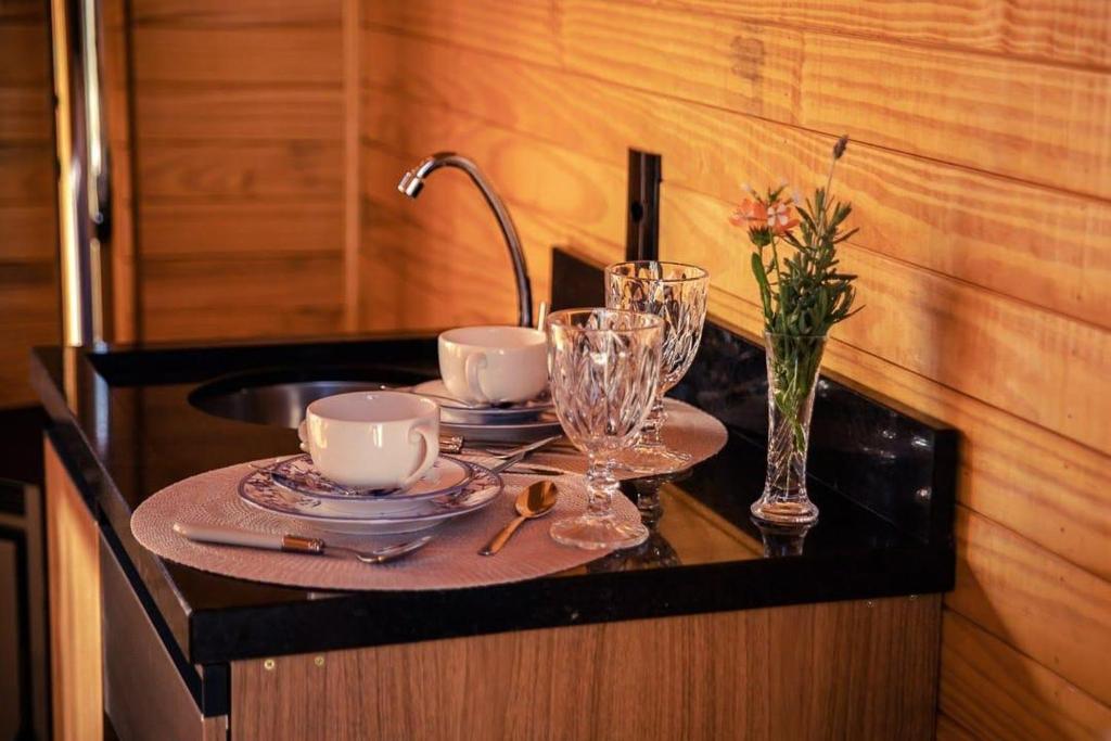 a table with plates and glasses and a sink at Blue Sunset in Urubici