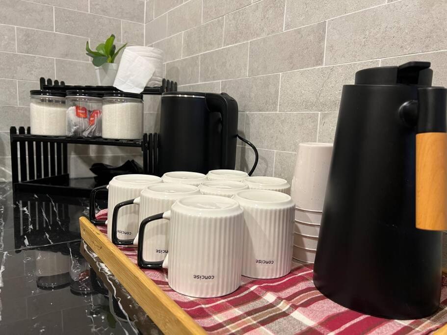 a group of cups sitting on top of a counter at RUMAH SAUJANA KLIA by IMPIAN HOMESTAY in Sepang