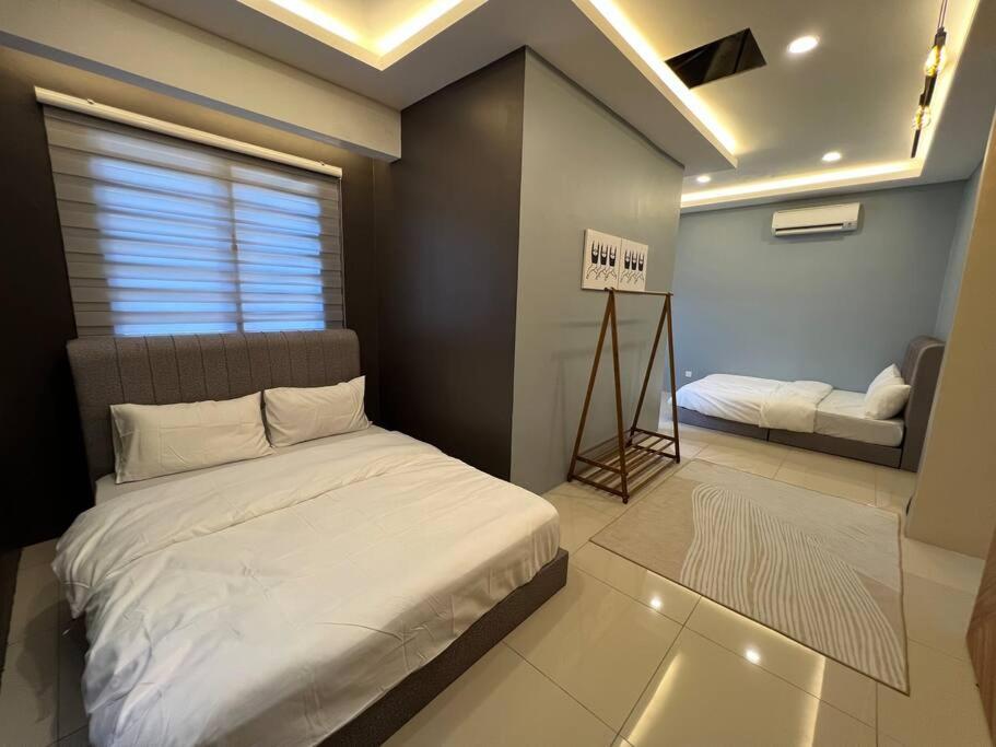 a bedroom with a bed and a couch in it at RUMAH SAUJANA KLIA by IMPIAN HOMESTAY in Sepang