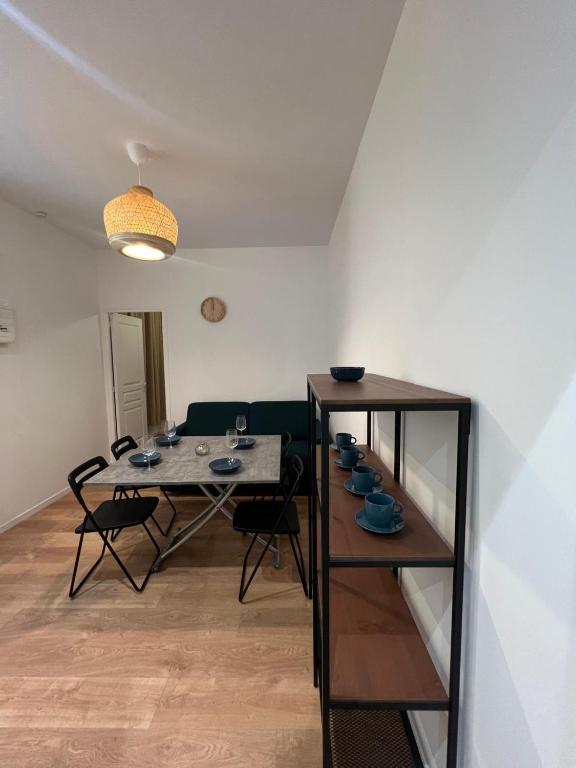- une salle à manger avec une table, des chaises et une étagère dans l'établissement Le Havre Montmartrois 2, à Paris