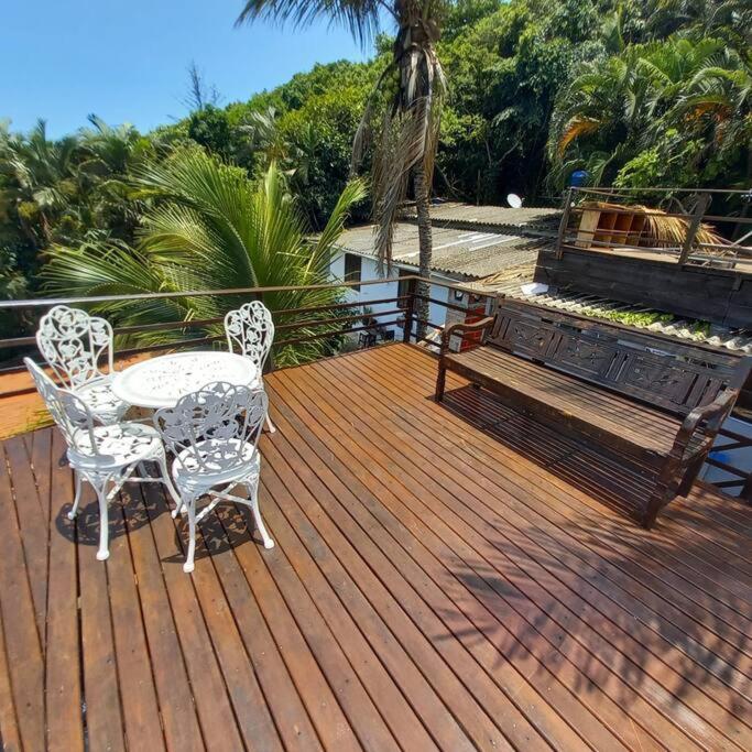 a wooden deck with a table and chairs and a bench at apartamento com Deck e vista mar - Loft Rocha in Rio de Janeiro