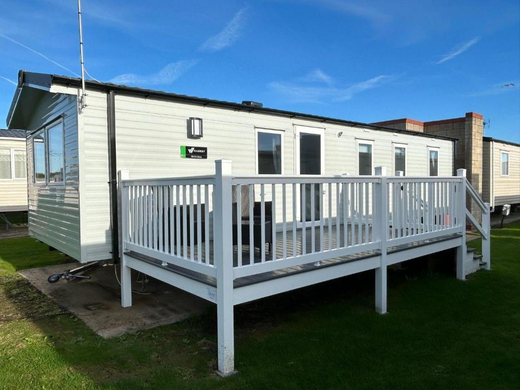 a mobile home with a porch and a deck at Beautiful 8 Berth Caravan With Decking At Naze Marine Holiday Park Ref 17344Br in Walton-on-the-Naze
