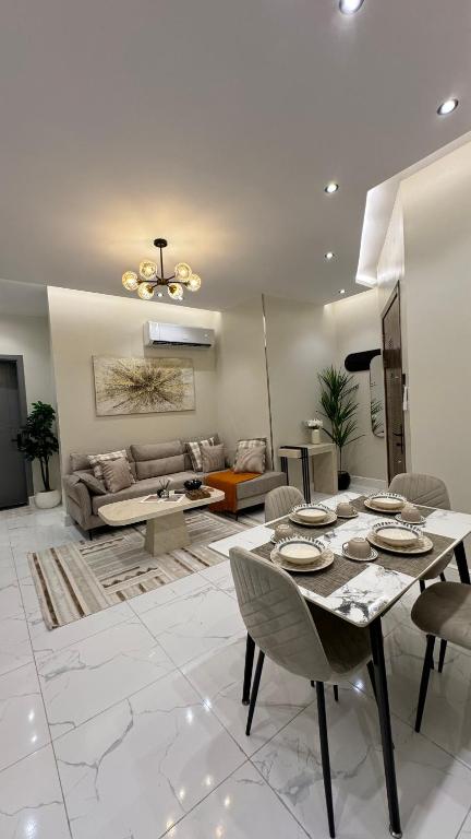 un soggiorno con un tavolo e un divano di وصول ذاتي Alsumo-apartment a Gedda