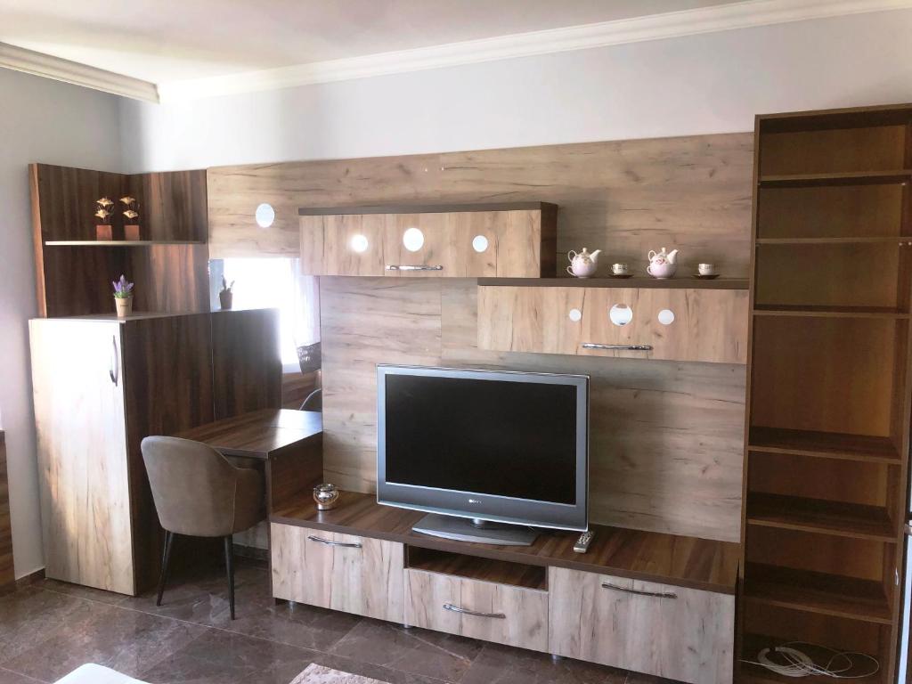 una sala de estar con TV en un centro de entretenimiento de madera en HOTEL ROOM CITY SQUARE with great VIEW no parking, en Skopje