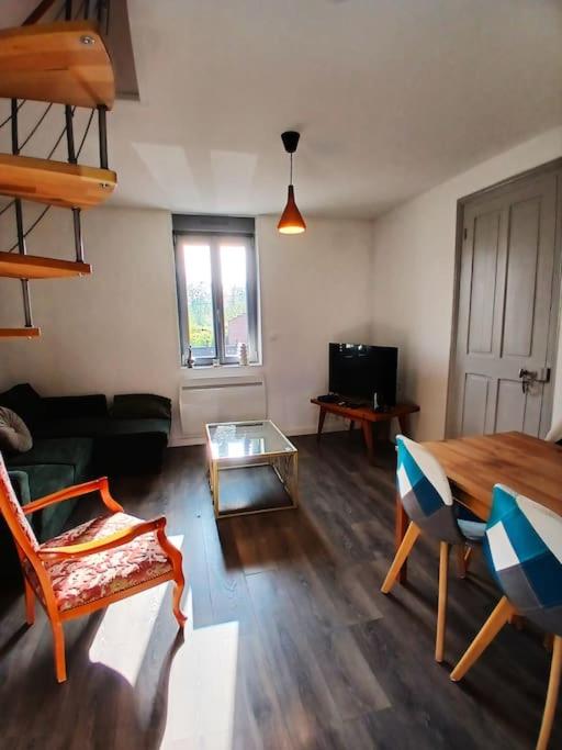 un salon avec une table et un canapé dans l'établissement Appartement T3 - Centre Cambrai, à Cambrai