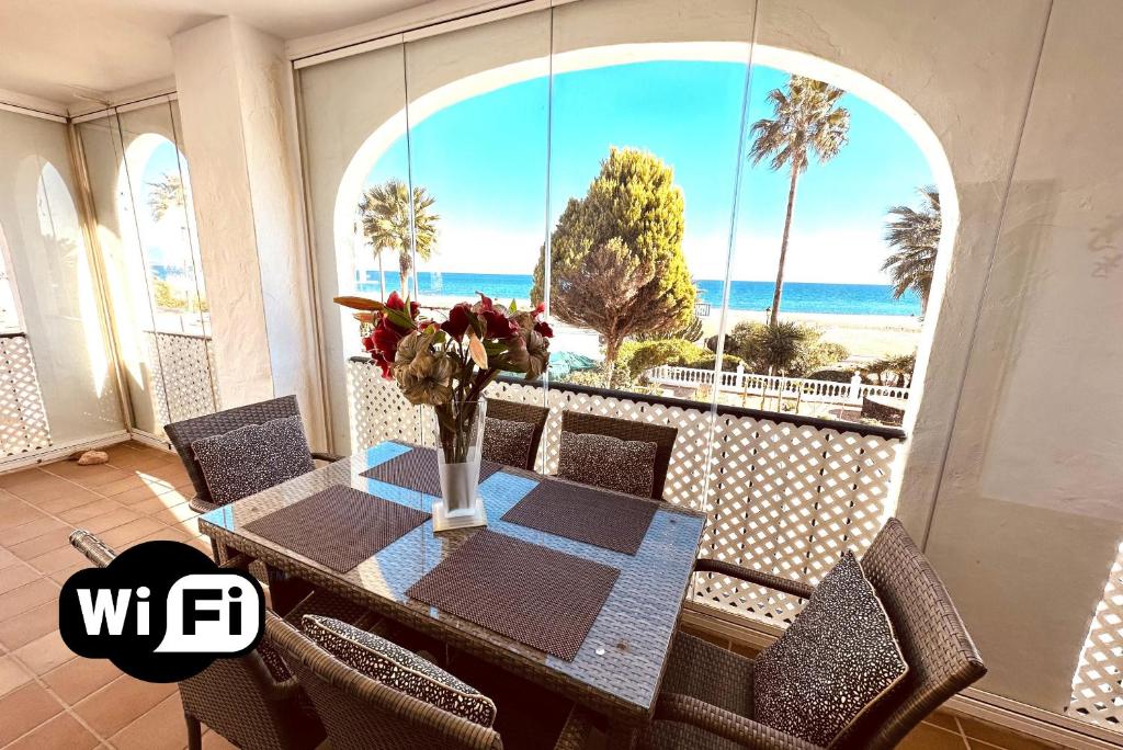a dining room with a table and a view of the ocean at 111 marina duquesa in Manilva