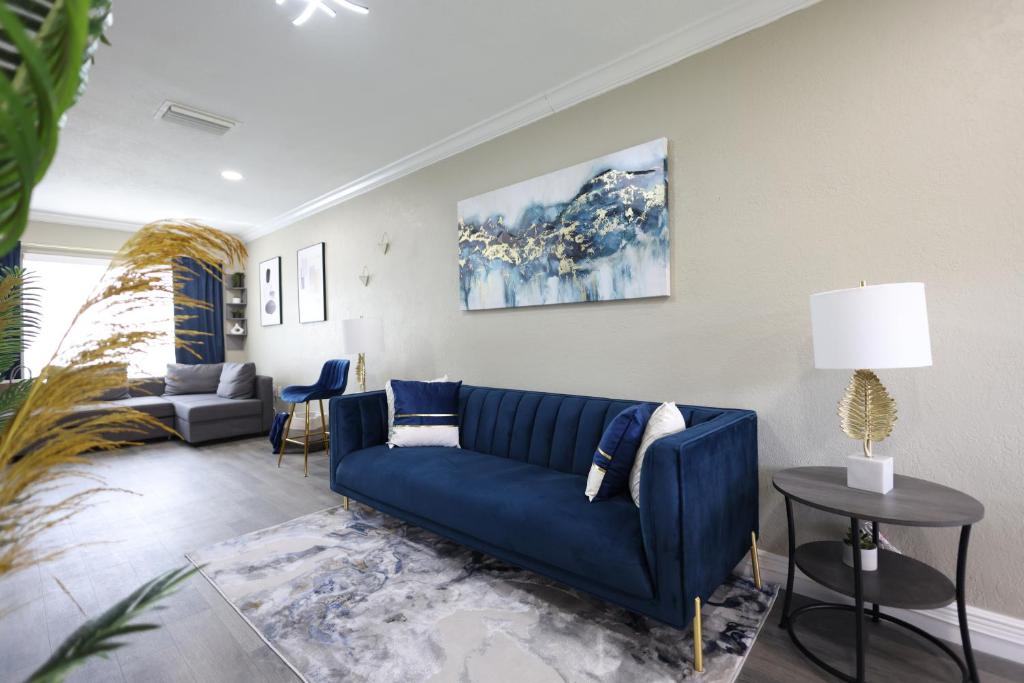 a living room with a blue couch and a table at Walk to Stadium - 3BR King Bed Haven - Parking in Miami Gardens