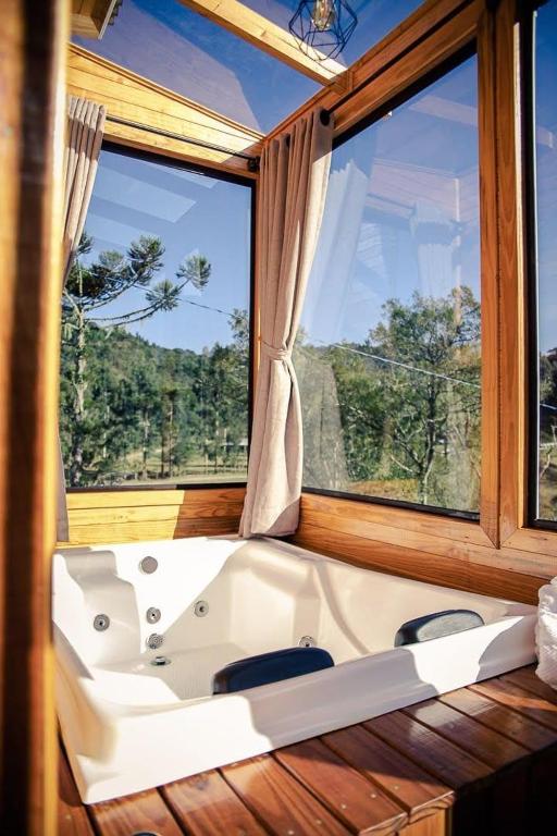 a bath tub in a room with a large window at Blue Sunset 2 in Urubici