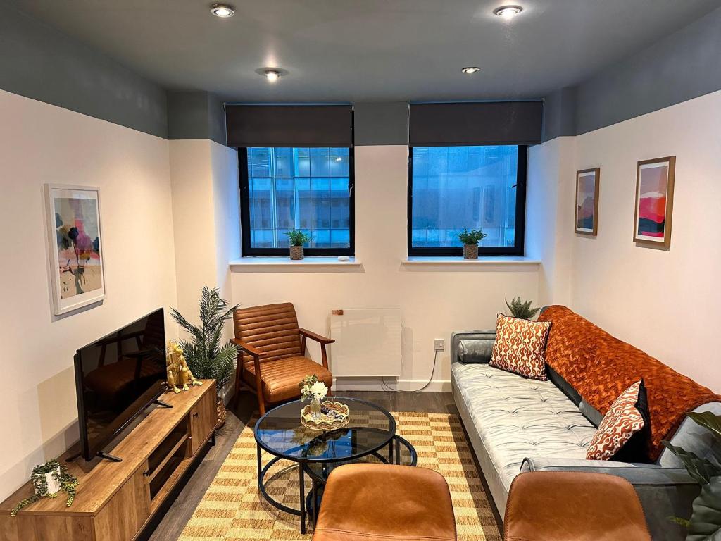 a living room with a couch and a tv at Stylish 2 bed City Retreat in Glasgow