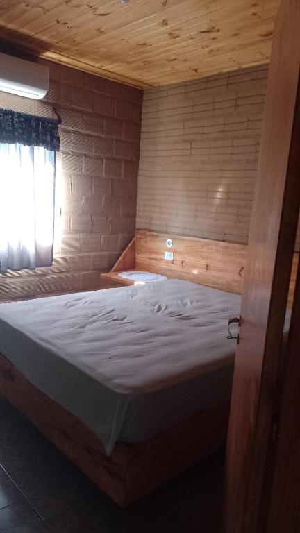 a large bed in a room with a window at hospedaje in Garupá