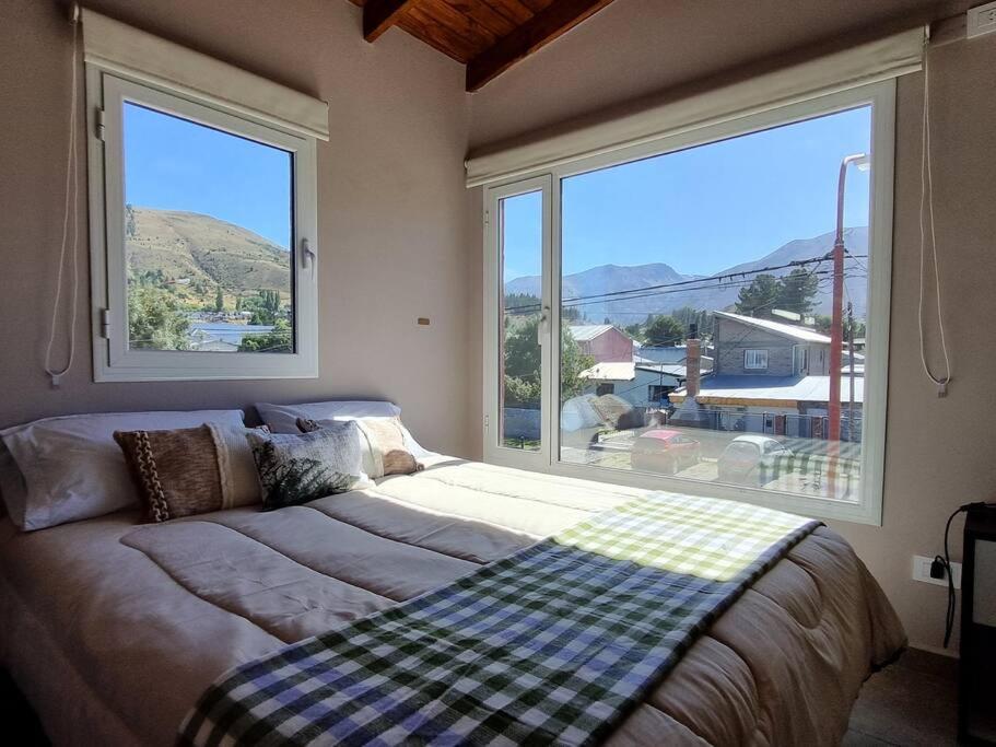 een slaapkamer met een bed en een groot raam bij Moderno Duplex 1 - Complejo Las Cerezas in Esquel