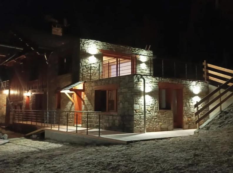 une maison en pierre avec des lumières allumées la nuit dans l'établissement Apartment Belle Vue, à Les Coches