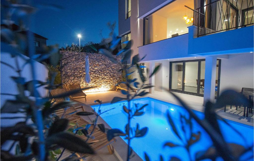 a house with a blue swimming pool at night at Beautiful Apartment With Pool in Žman