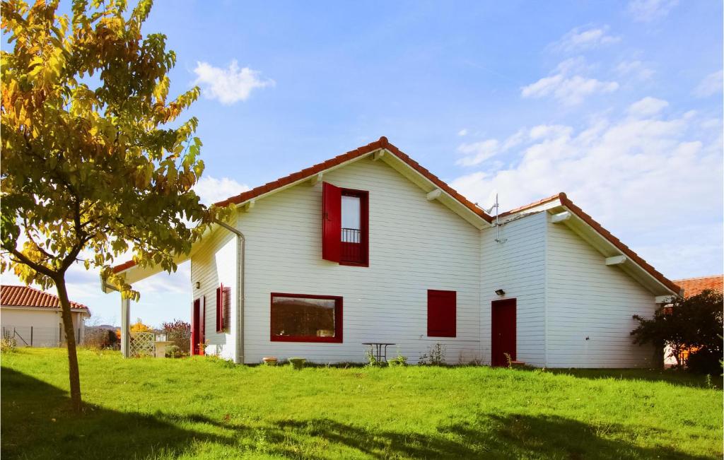 une maison blanche avec des fenêtres rouges sur un champ vert dans l'établissement Cozy Home In Vernoux En Vivarais, à Vernoux-en-Vivarais