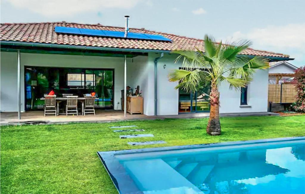 une maison avec un palmier et une piscine dans l'établissement Awesome Home In La Teste-De-Buch, à La Teste-de-Buch