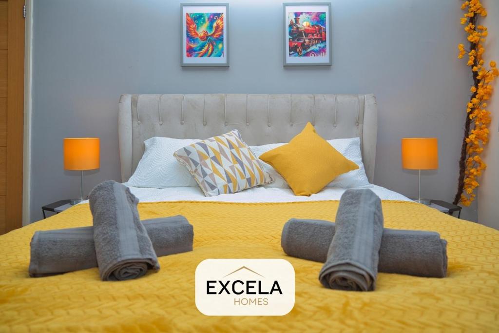 a bed with a yellow blanket and pillows on it at Potter's Cove in Watford - Walk to the Studios in Leavesden Green