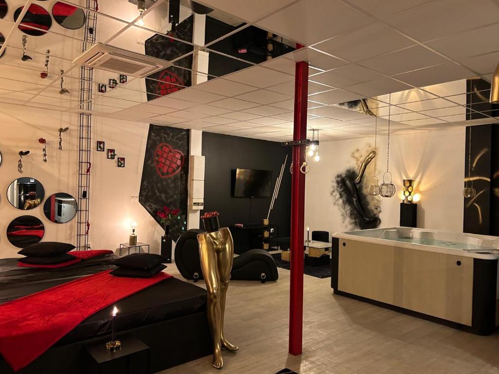 a room with a bed and a table in a room at L'escapade sensuelle - la love room d'Epernay in Épernay