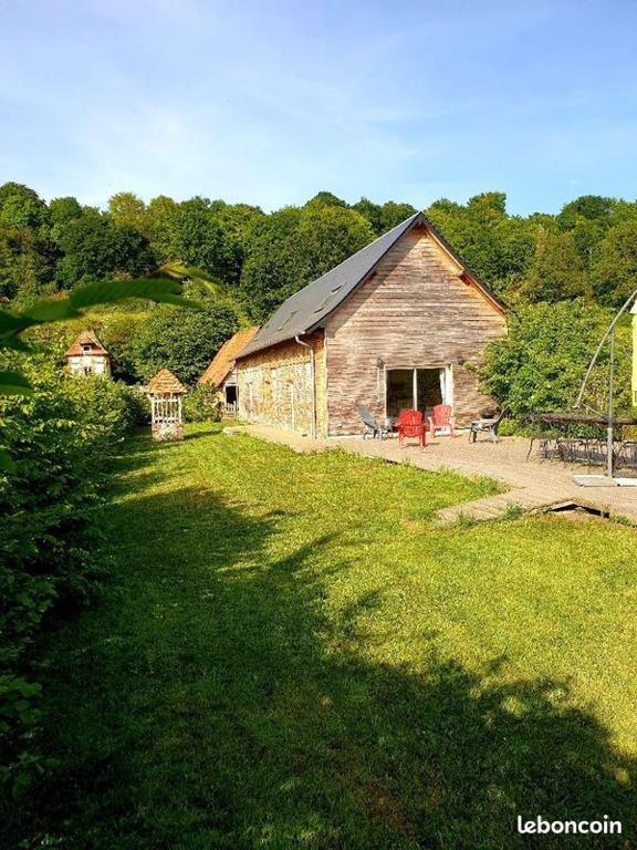 une ancienne grange dans un champ d'herbe verte dans l'établissement Les écuries du Mesnil aux Moines, à Osmoy-Saint-Valery