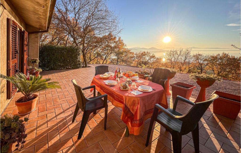 a table and chairs on a patio with the sunset at Awesome Home In San Savino Di Magione in San Savino