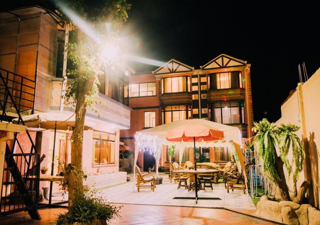 a building with a table and umbrella in front of it at Las Tholas Hotel in Uyuni