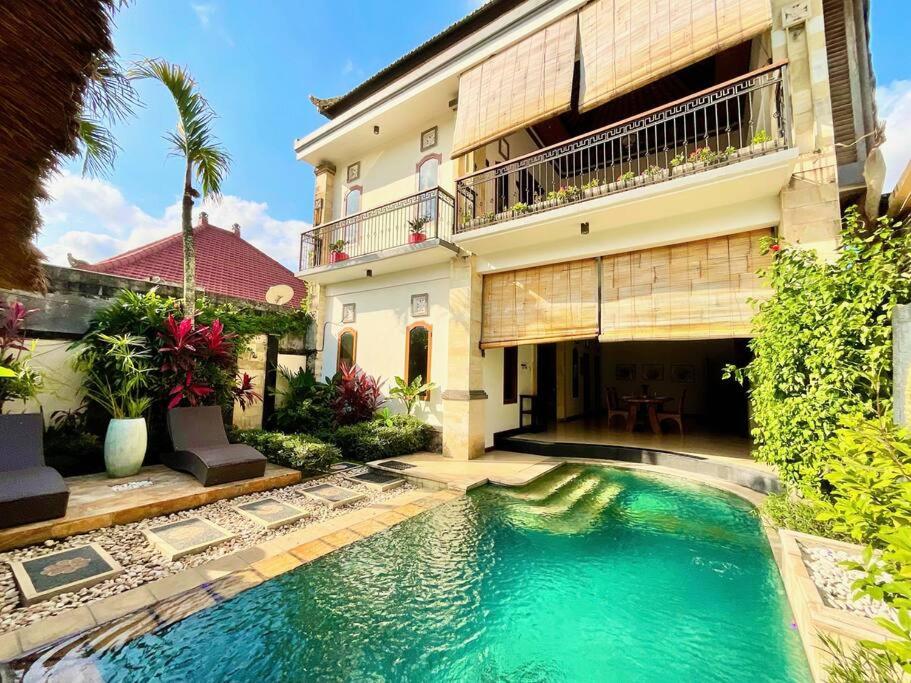 a swimming pool in front of a house at Pleasant Balinese Style Lotus in Umalas
