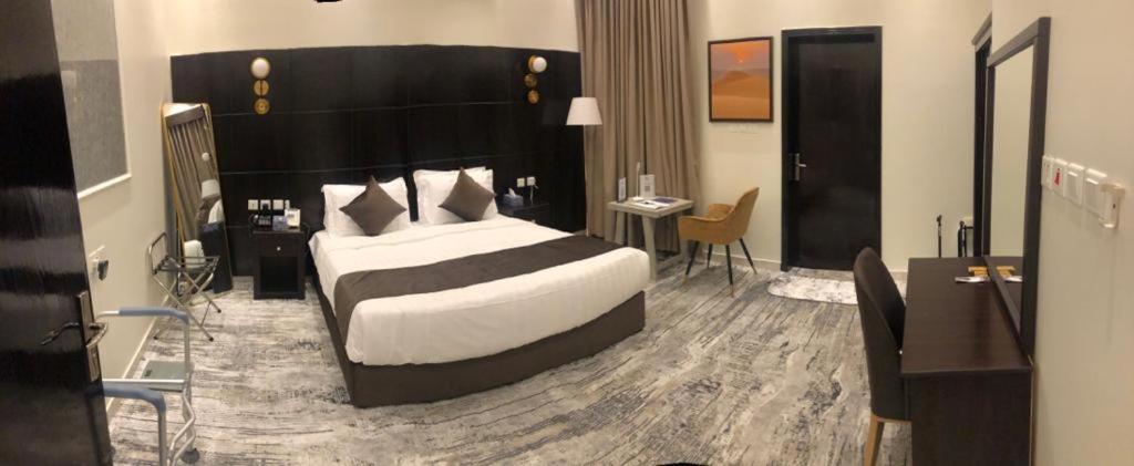 a bedroom with a large bed and a desk at فندق جون in Abha