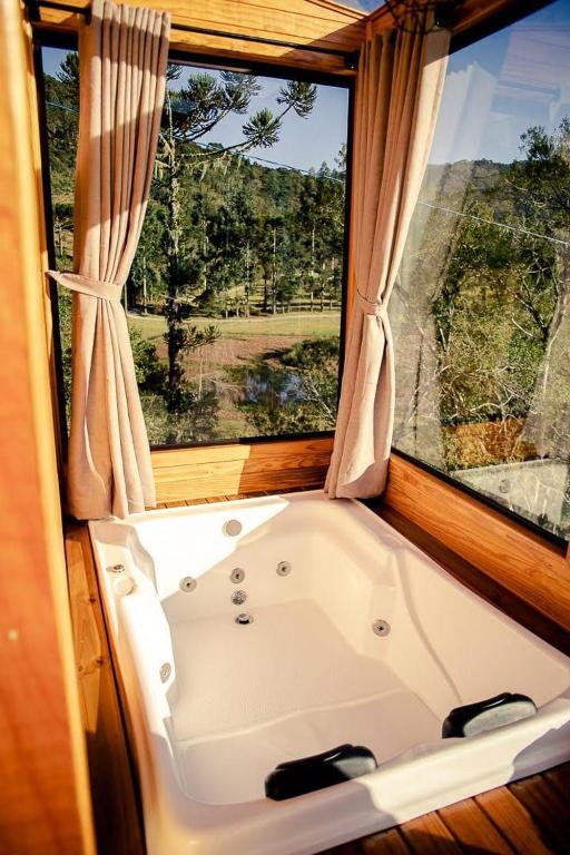 a bath tub in a room with a window at Blue Sunset 3 in Urubici