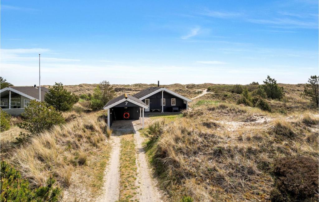 a house in the desert with a dirt road leading to it at Holiday Home Bunken 7 in Ålbæk