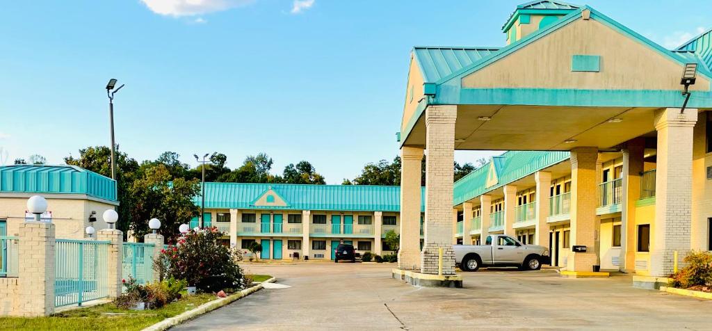 Un edificio con un coche aparcado en un estacionamiento. en Western Inn Express, en Hazlehurst