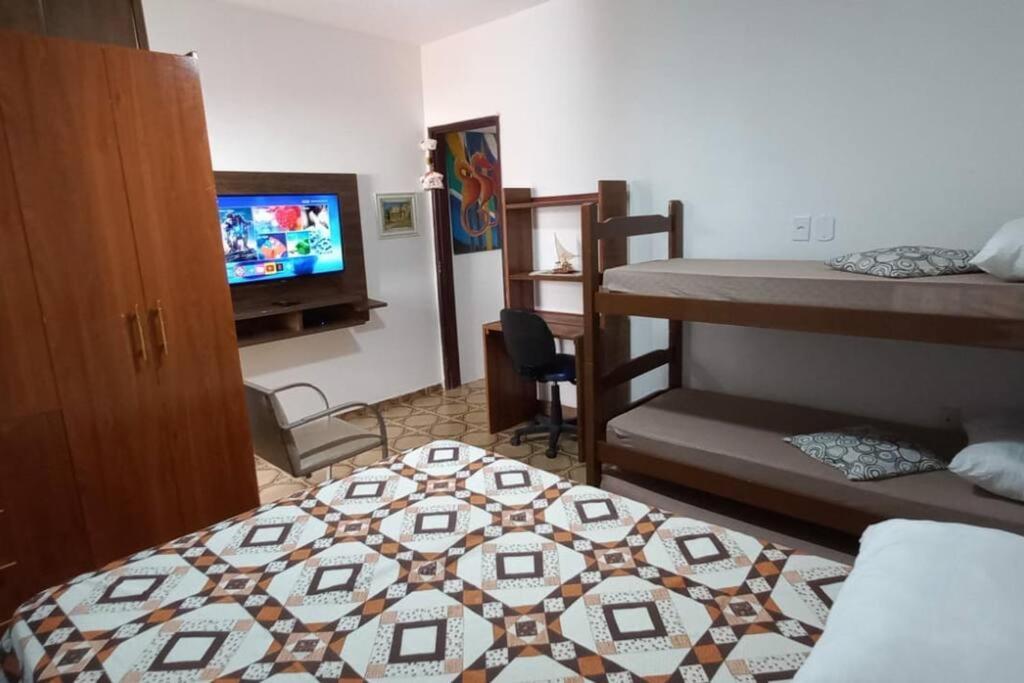 a room with two bunk beds and a television at Colonial Praiano in Guarapari