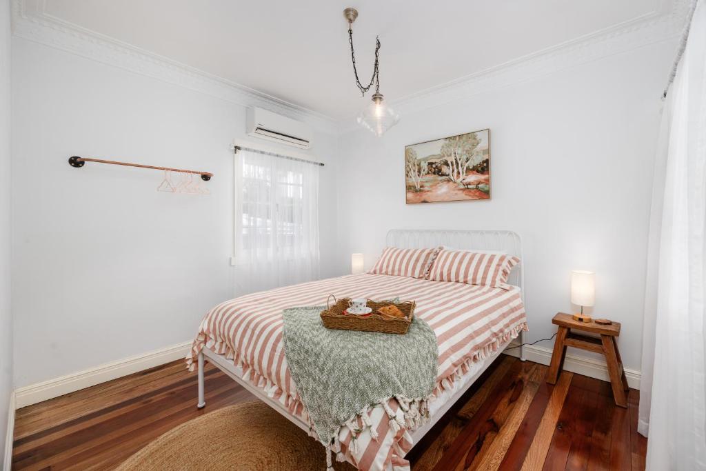Un dormitorio blanco con una cama y una mesa. en Cottage on Lamington, en Canungra