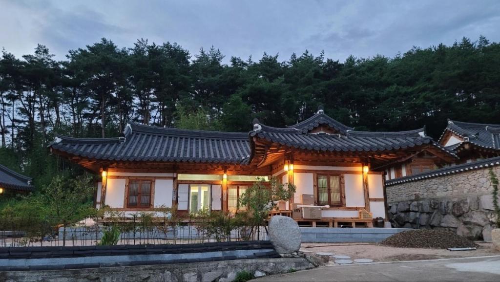 a house with an asian roof with lights on it at Lee Cho Hanok in Gyeongju