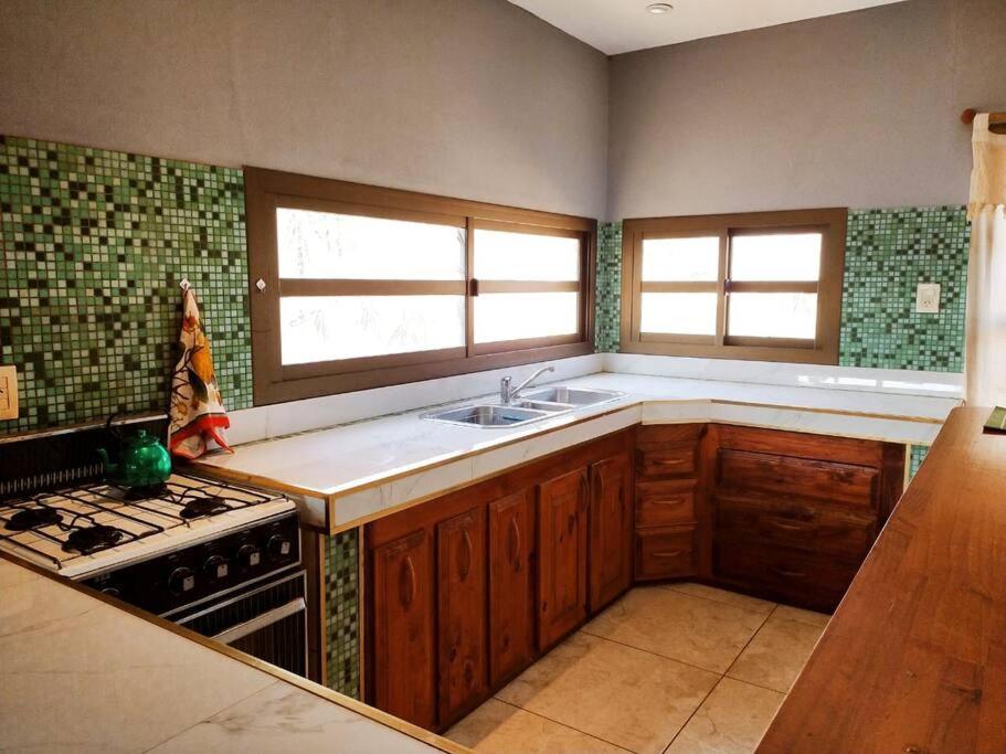 a kitchen with a sink and a stove at Casa con piscina, monte y selva en Misiones in Puerto Rico