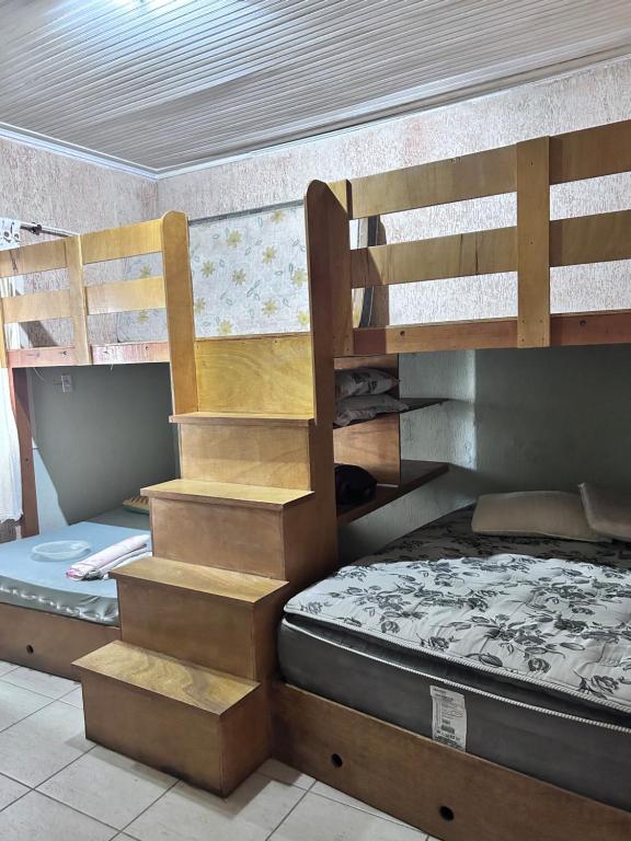 two bunk beds in a room with a bed at Casa de Praia Itanhaém in Itanhaém