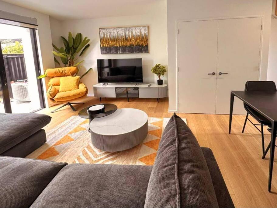 una sala de estar con un sofá y una mesa en Cosy Wanaka Townhouse, en Wanaka