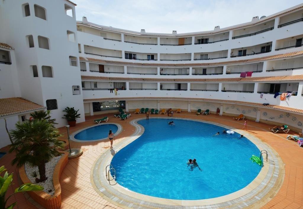 une grande piscine en face d'un grand bâtiment dans l'établissement Nautilus Apartment, à Armação de Pêra
