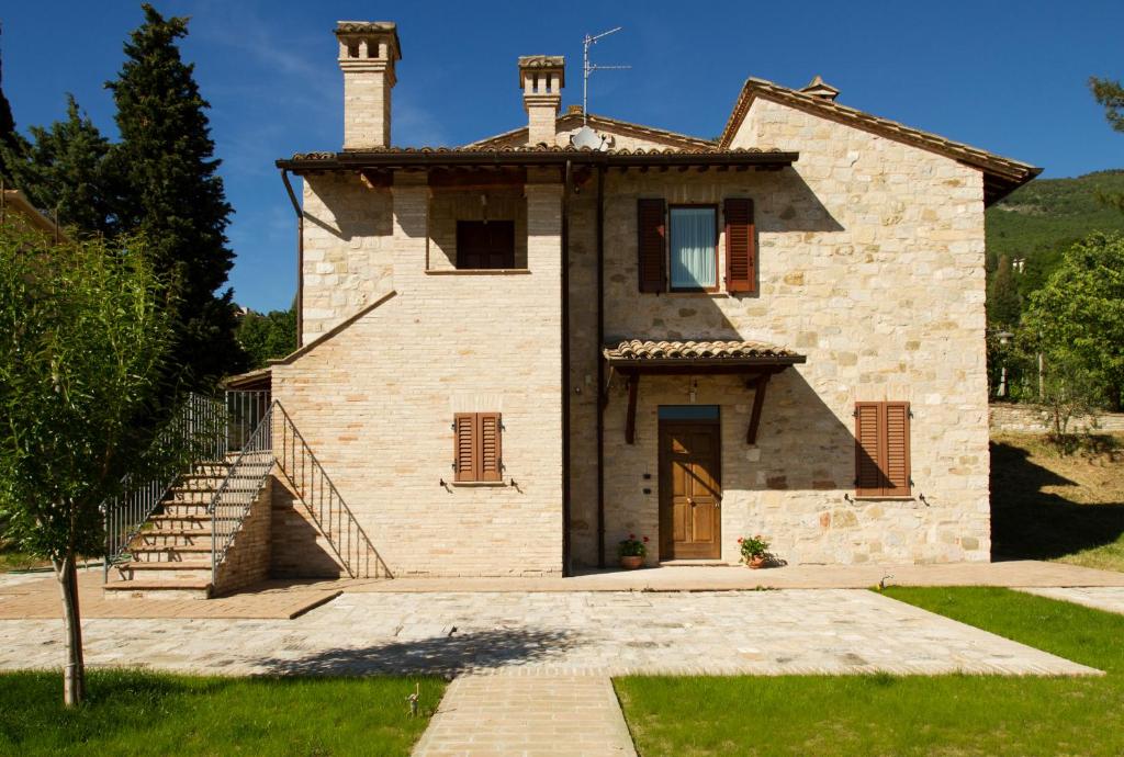 an old stone house with a staircase and a door at Villa Degli Ulivi in Assisi