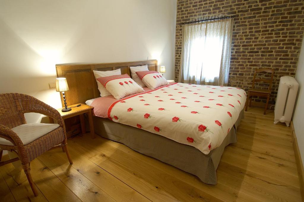 a bedroom with a bed and a chair and a window at Vakantiewoning Venderhof in Maaseik