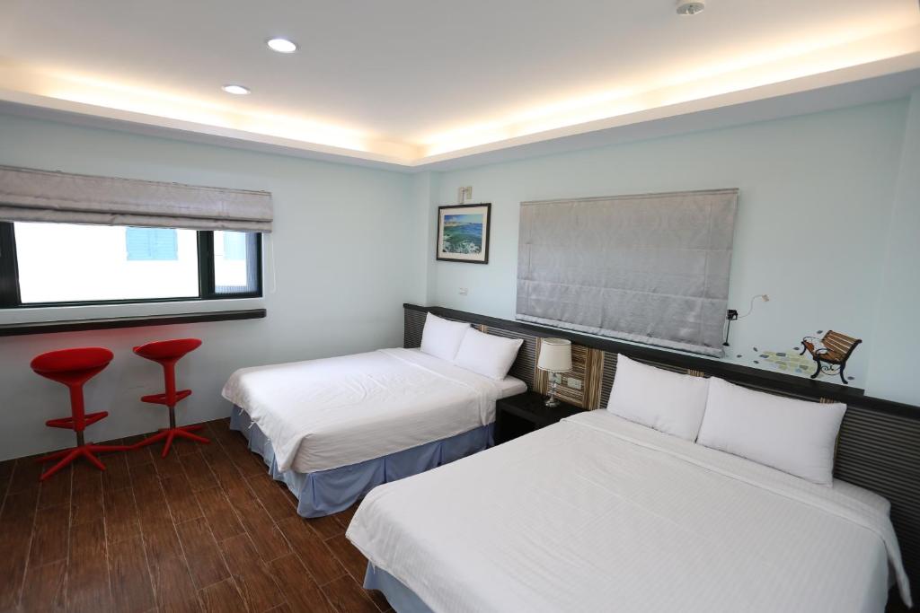 a hotel room with two beds and a window at See Your Dreams B&amp;B in Magong