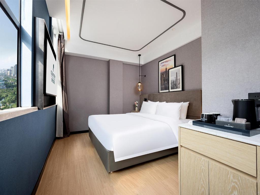 Postel nebo postele na pokoji v ubytování Country Inn & Suites by Radisson Shenzhen International Convention and Exhibition Center