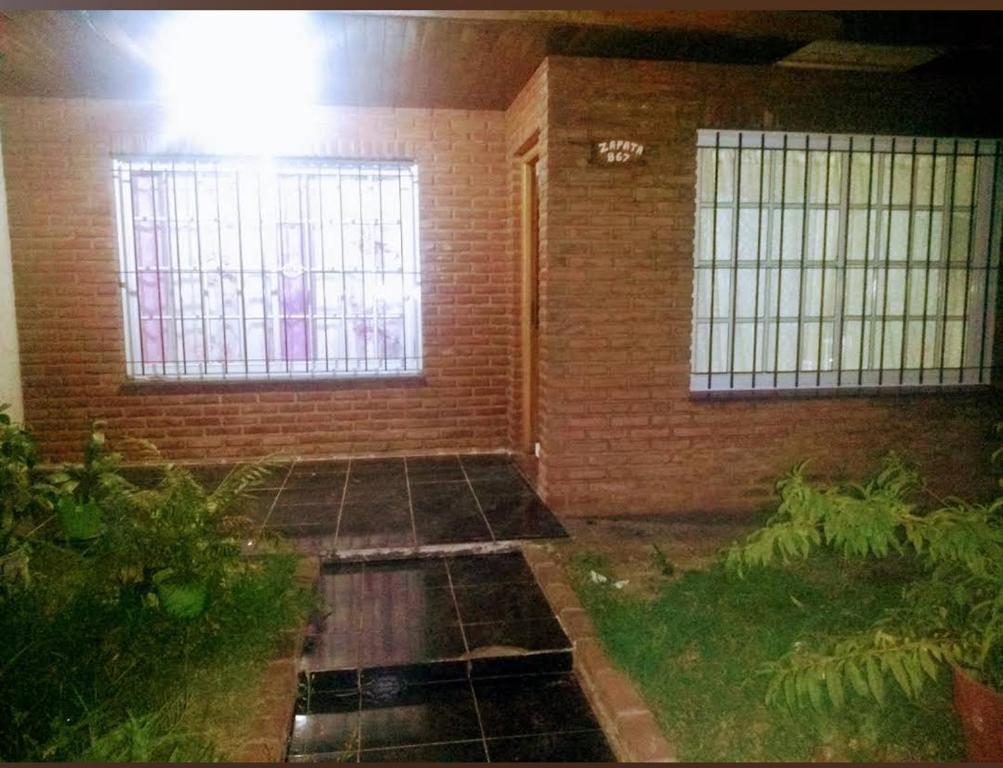 a room with a brick wall and a window at La casa de la ti in Lanús