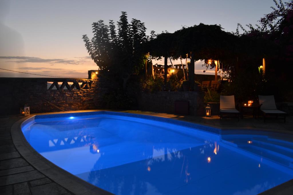 a swimming pool in a backyard at night at Villa Santa Mavra in Glinado Naxos