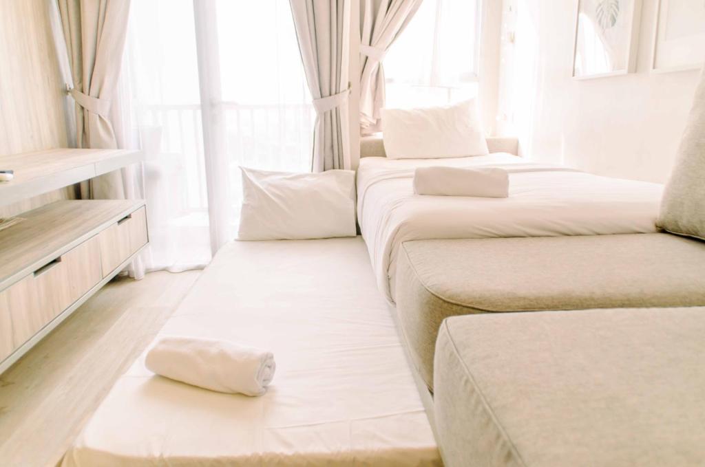 a room with three beds and a window at Simple and Cozy Living Studio Room at Poris 88 Apartment By Travelio in Tangerang