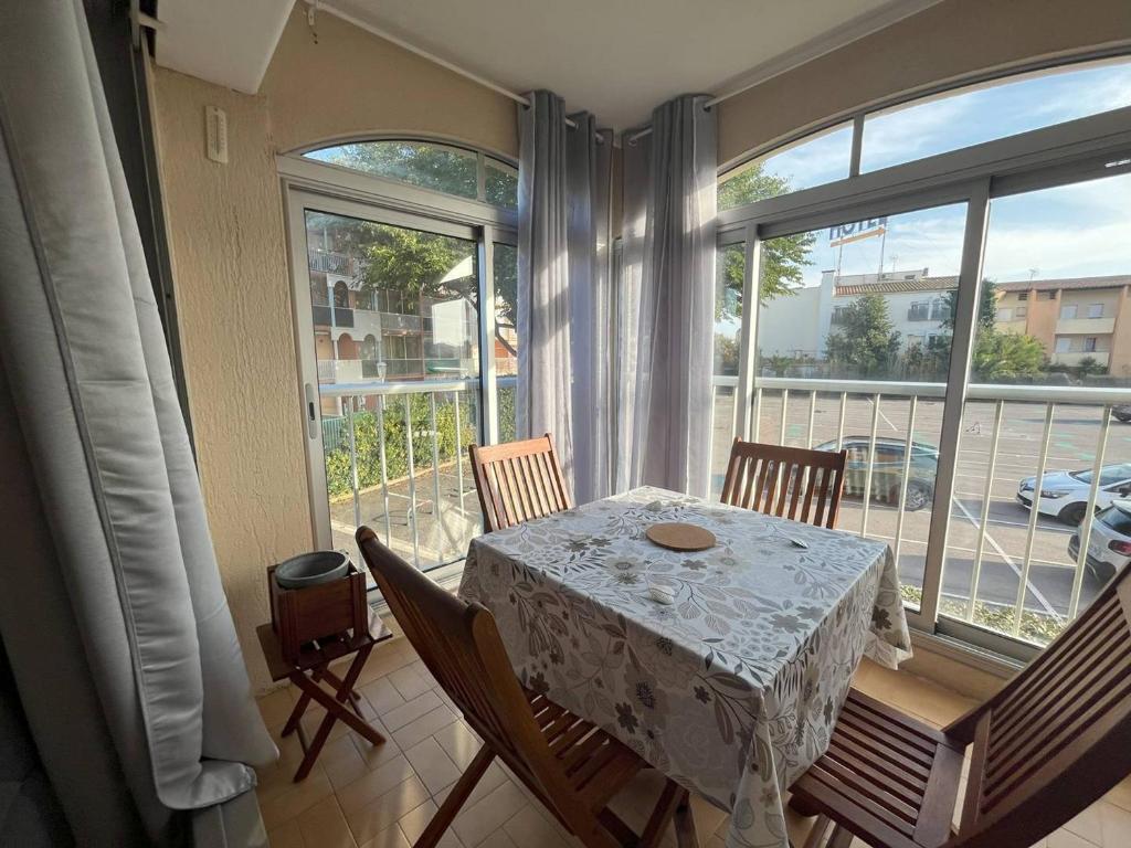 une salle à manger avec une table et une grande fenêtre dans l'établissement T2 Cabine rénové Cap d'Agde: 4 pers, parking, prox plages - FR-1-749-74, au Cap d'Agde