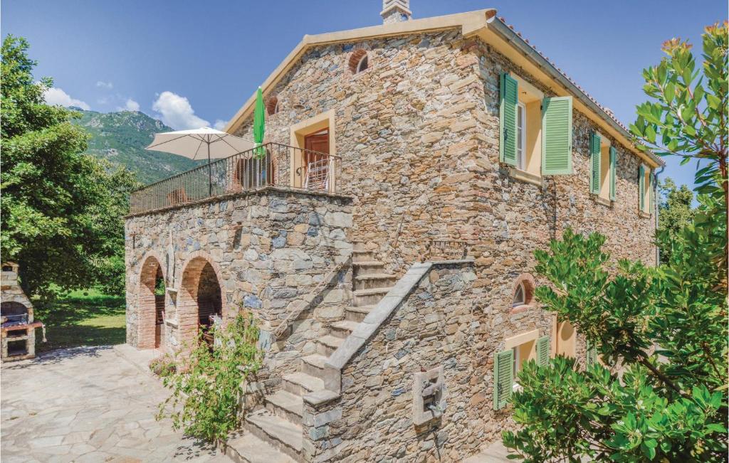 Elle offre une vue sur l'extérieur d'une maison en pierre dotée d'un balcon. dans l'établissement Beautiful Home In Santa Maria Poggio, à Santa-Maria-Poggio