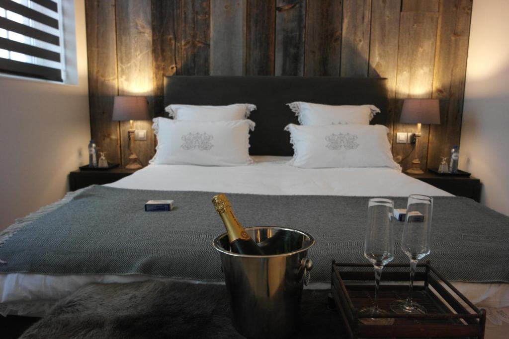 uma cama com uma garrafa de champanhe e dois copos em B&B Sixteen em Bruges