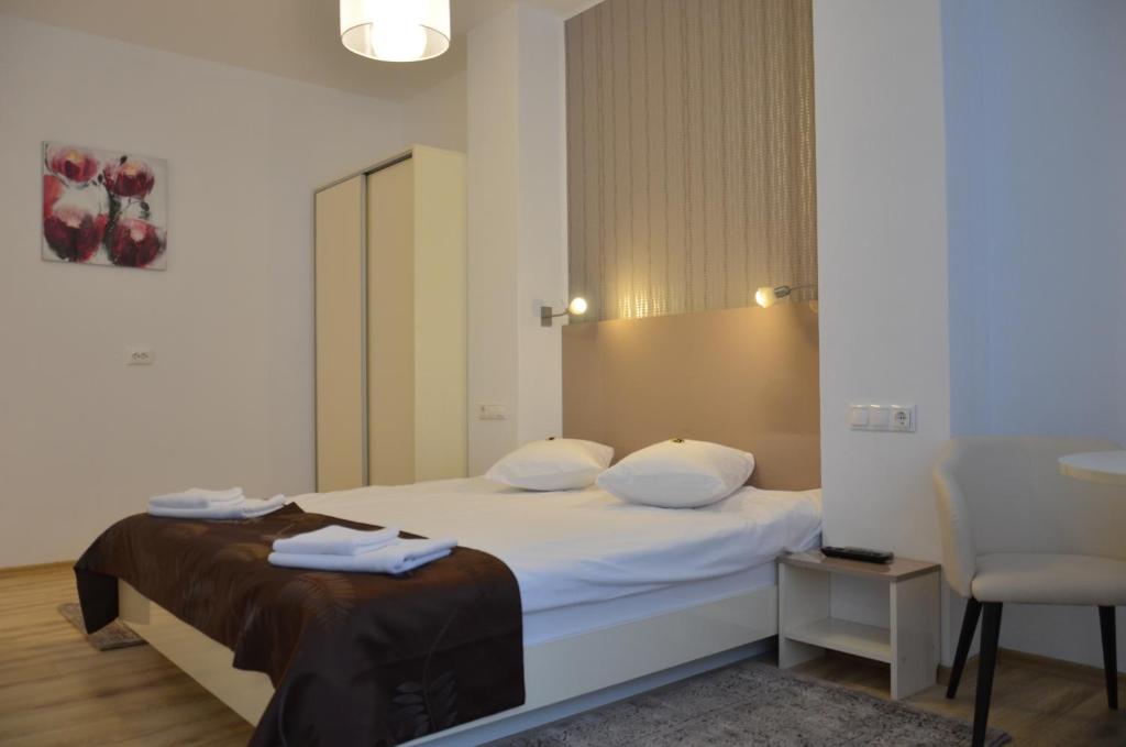 a hotel room with a bed and a chair at ApartHotel Zorilor in Cluj-Napoca