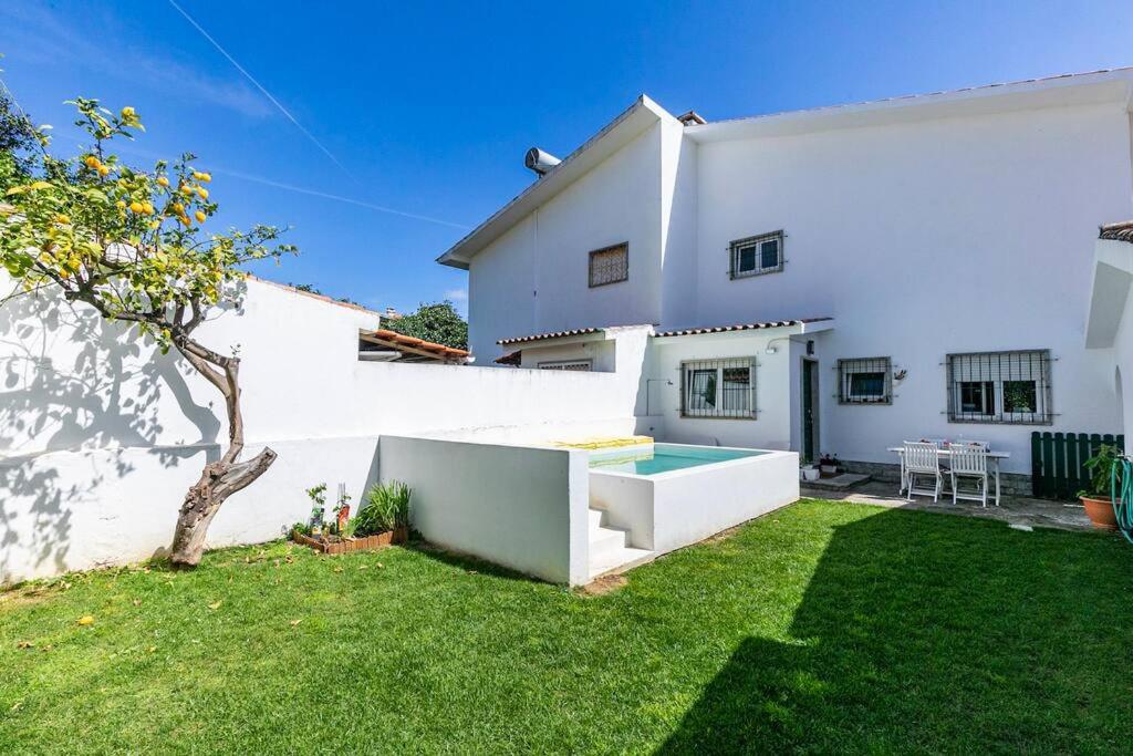 una casa bianca con piscina in un cortile di Estoril Beach Villa a Estoril
