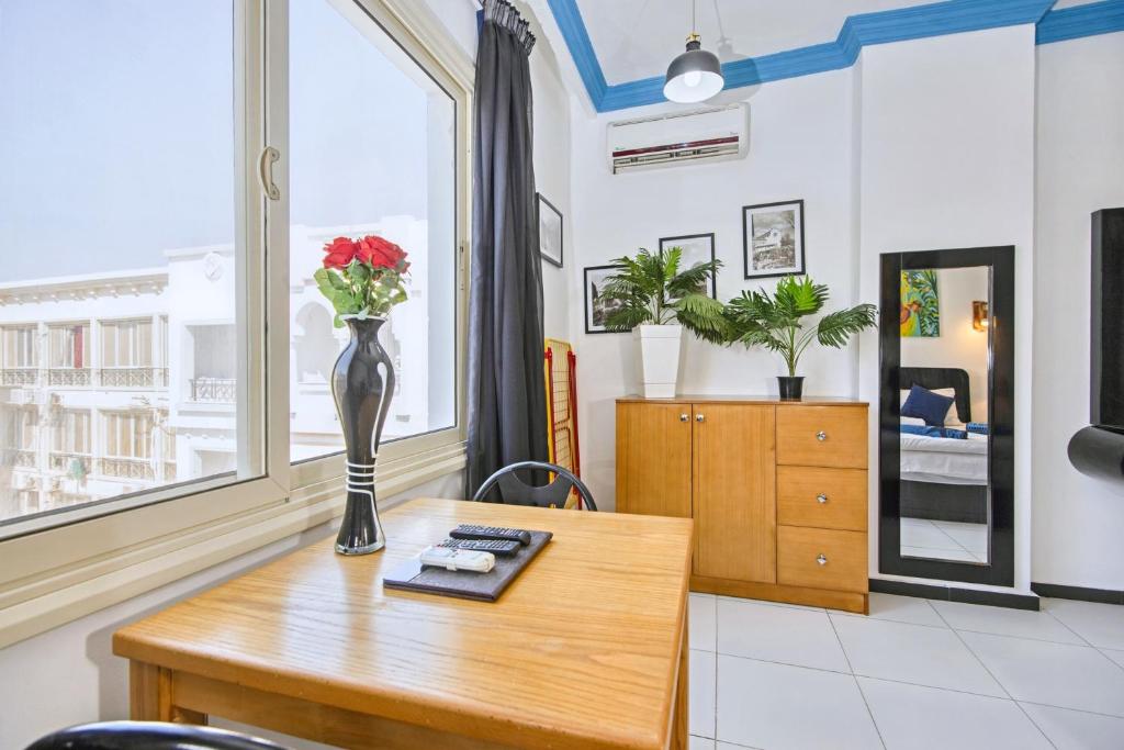 a vase of flowers on a table in a room at Rare New Marina Hotspot With Pool & Fast Free WIFI - Western Standards - Sheraton Plaza 415 in Hurghada
